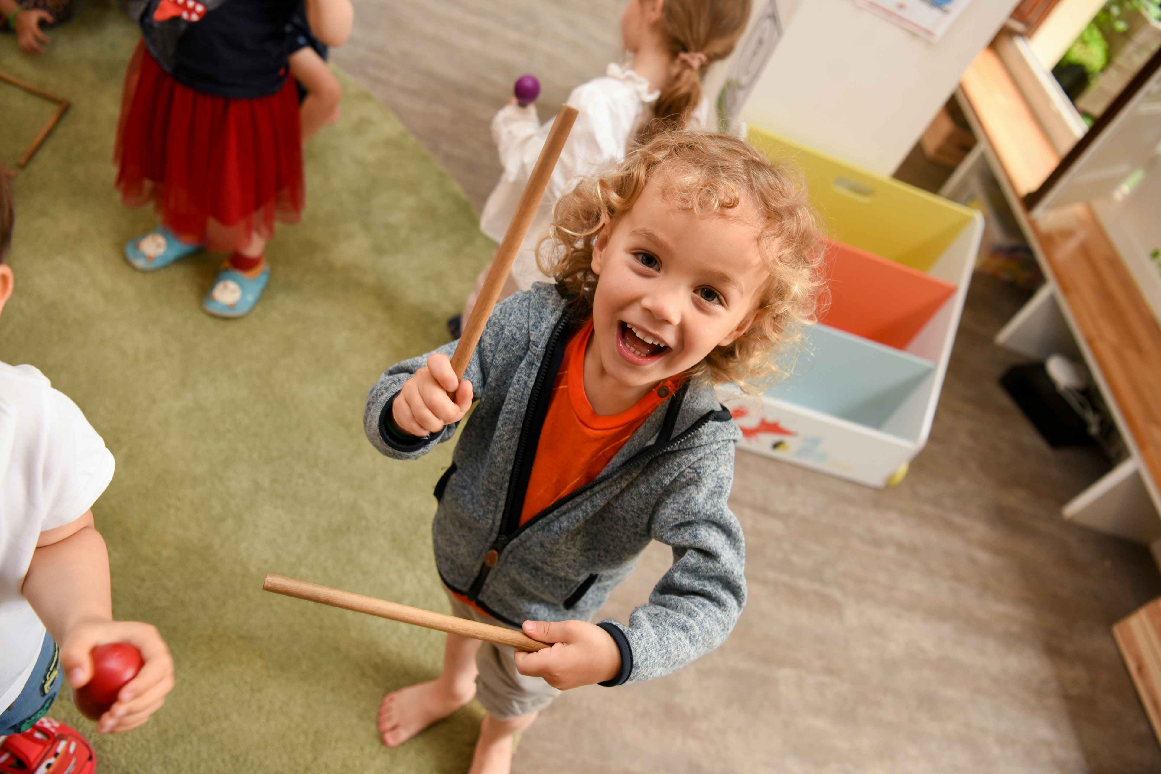 A young student has fun with drumsticks in a classroom